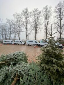 Four Enterprise vans parked on car park with Christmas trees in foreground before the Treecycle