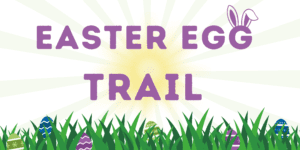 Purple 'Easter egg trail' text with grass at bottom with easter eggs hiding