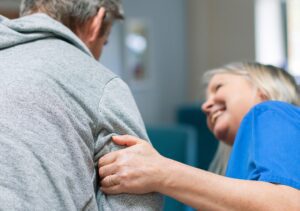 Hospice nurse holds the arm of a patient